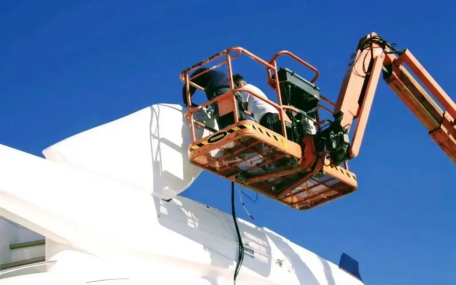 Technician applying a certified marine coating system to a yacht hull.
